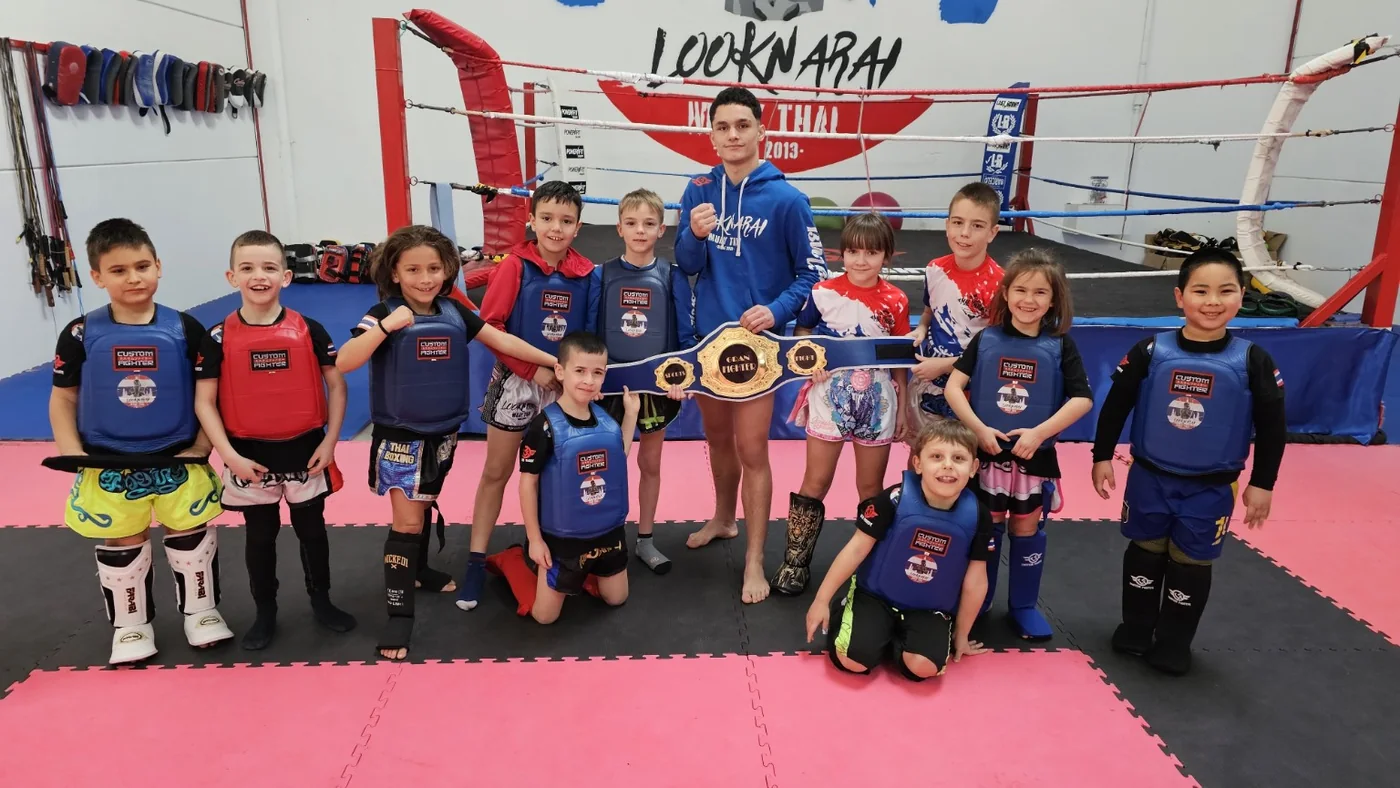 Grupo infantil de Looknarai con jóvenes alumnos y un cinturón de competición, en la escuela